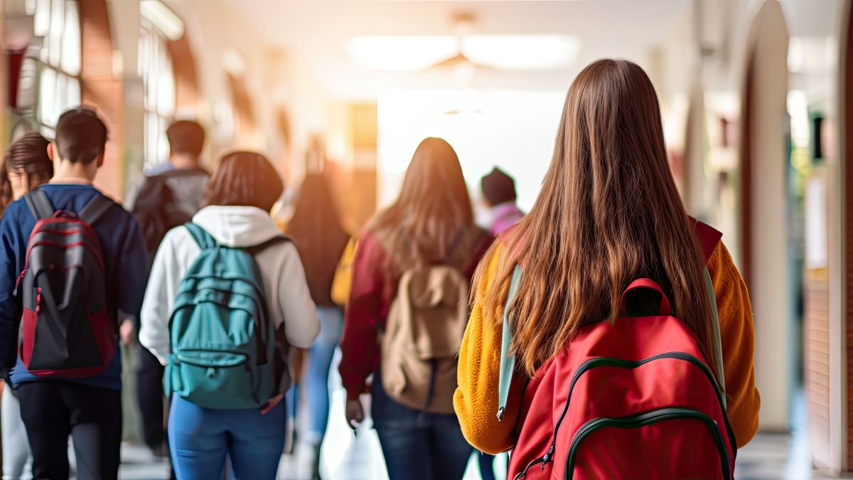 Uczniowie z plecakami na szkolnym korytarzu