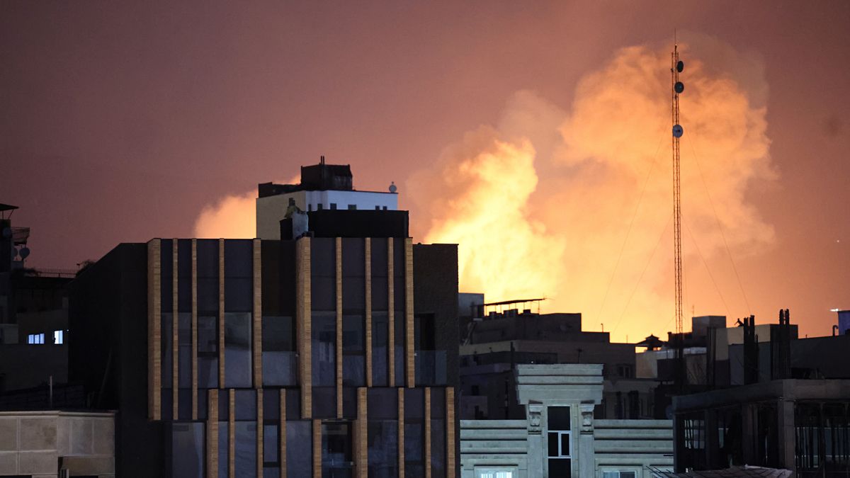 Dym i płomienie unoszą się za budynkami po eksplozji w Teheranie