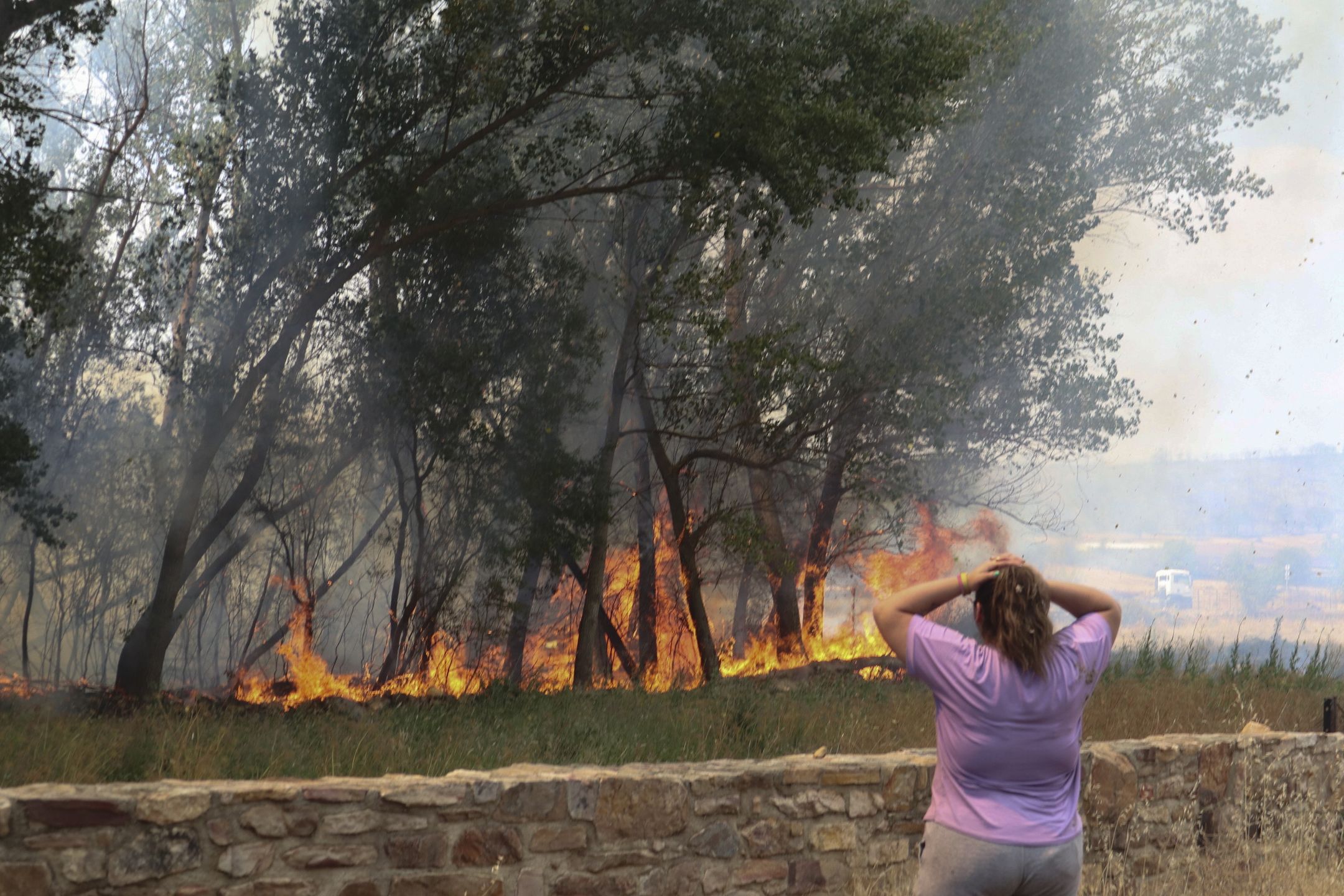 A woman reacts as she watches the flames from a fire in the village of San Martin de Tabara (Zamora), Spain, 18 July 2022. The heat wave sweeping across Spain is fueling forest fires in five Spanish regions. EPA/MARIAM A. MONTESINOS Dostawca: PAP/EPA.