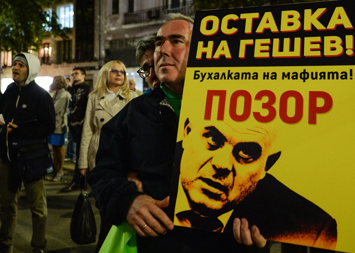 Uczestnik demonstracji przeciwko korupcji władzy w Bułgarii trzyma w ręku portret niechcianego prokuratora Iwana Geszewa