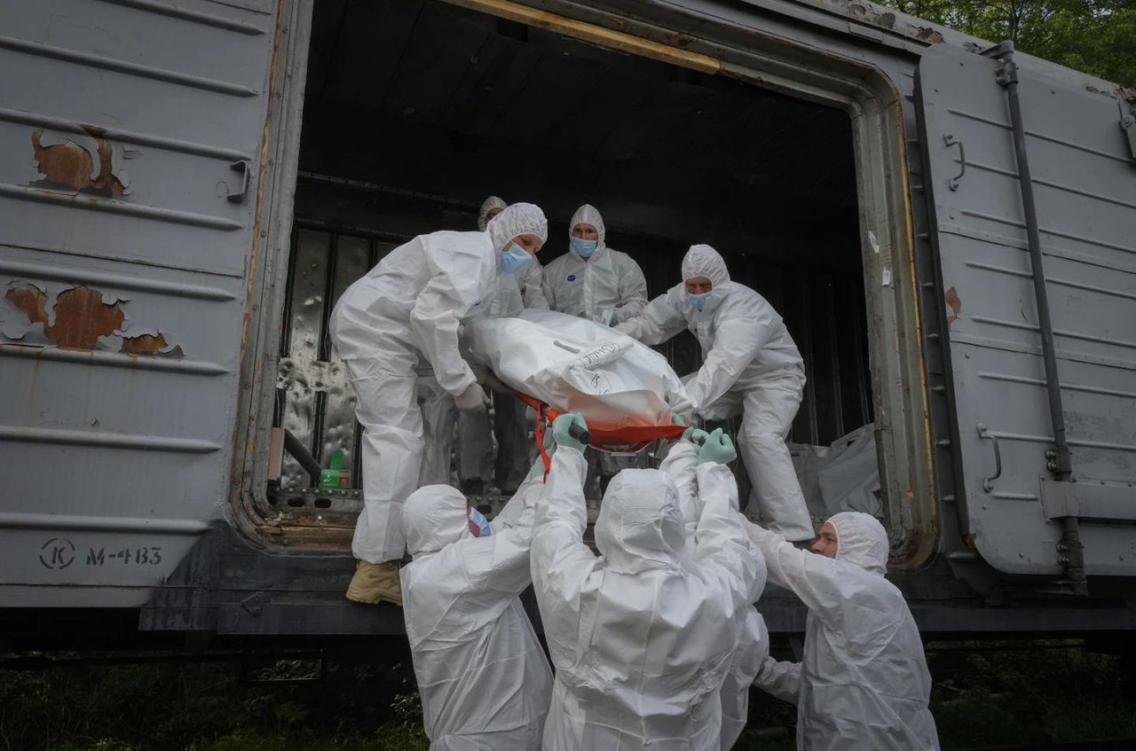 Ukrainian soldiers load the bodies of dead Russians into a refrigerated wagon. Kyiv, May 13, 2022