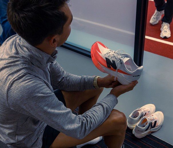 Mężczyzna przebierający buty NewBalance na siłowni - zdjęcie.