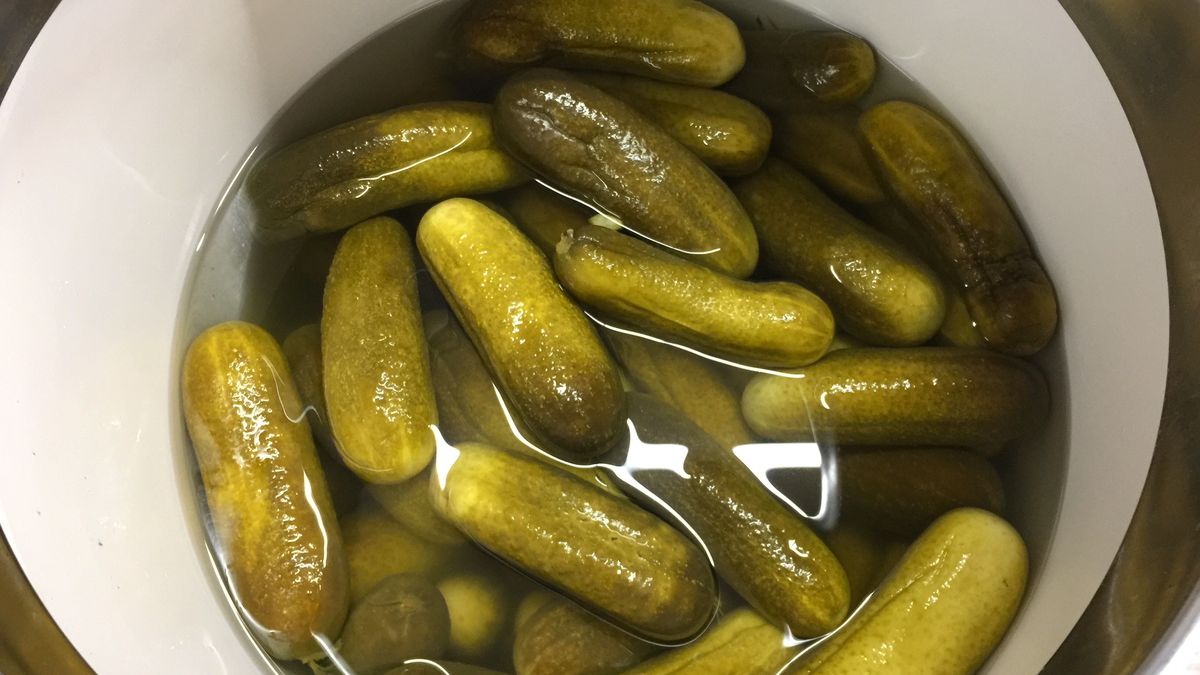 Salted, crunchy cucumbers lie in brine in a barrel.Salted, crunchy cucumbers lie in brine in a barrel.Borisenkov Andrei