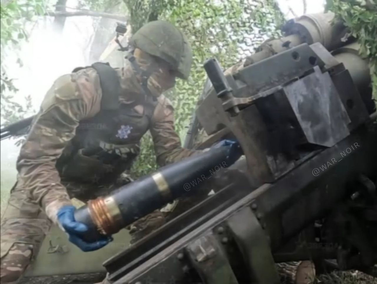 A Russian loading a North Korean missile into an M-46 cannon.