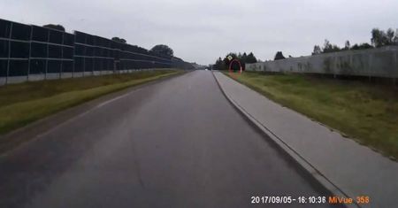 Alarm24: Policjant schowany za ogrodzeniem dokonuje pomiaru prędkości