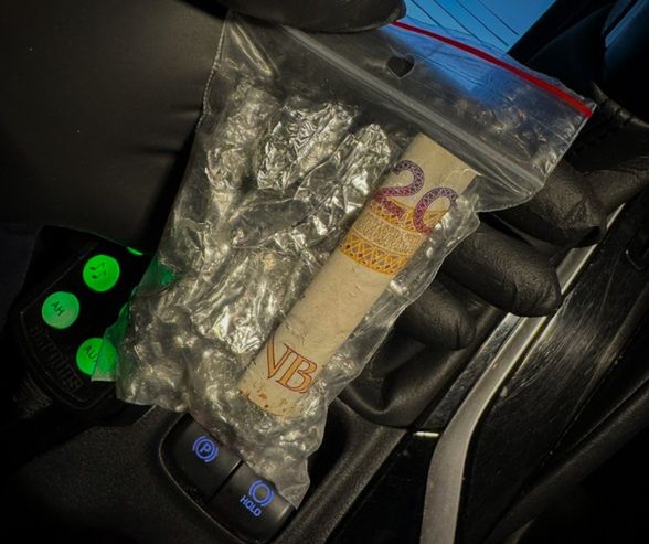 Zamknięta w przezroczystej torebce strunowej banknot dwudziestozłotowy obok kryształków.