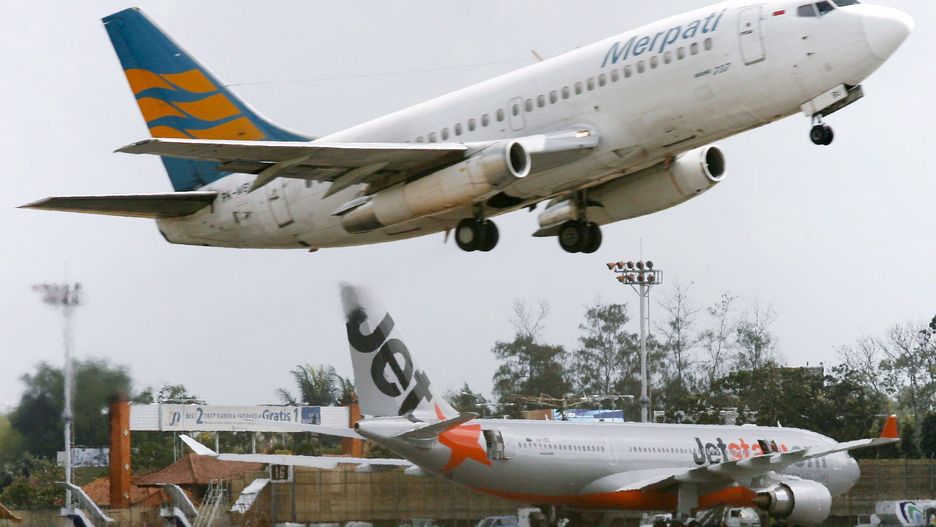 An Indonesian airplane flies over a parked Jetstar plane
epa01074481 An Indonesian airplane flies over a parked Jetstar plane flight JQ30 from Bangkok to Melbourne after an emergency landing at Bali's airport in Denpasar, Bali, Indonesia on 23 July 2007. The pilot re-routed the three-week old Airbus 330-200 plane with 302 passengers and 12 crews on board, to Denpasar airport after shutting down one of the two engines, a report said.  EPA/MADE NAGI
Dostawca: PAP/EPA.
MADE NAGI