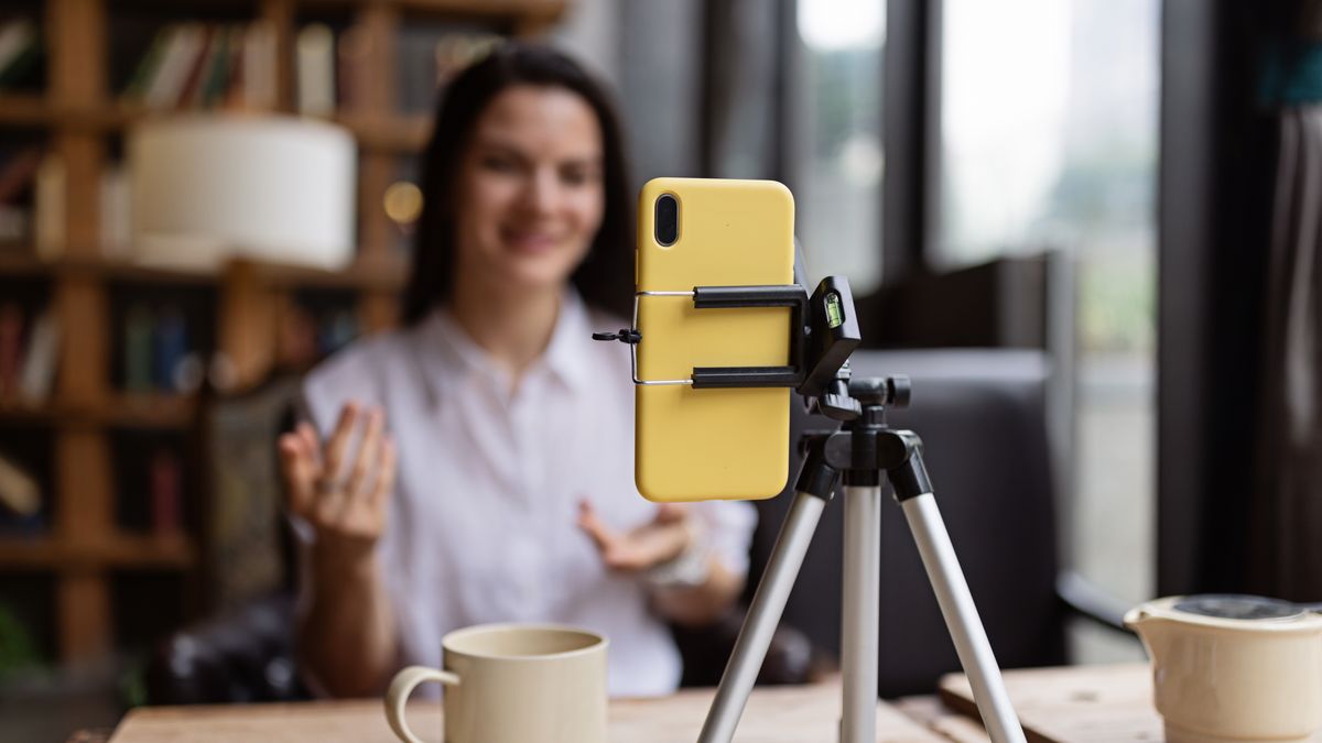 Happy young Caucasian millennial or gen z woman with long brunette hair streaming with smart phone on tripod, shooting social media blog in modern cafe. Influencer using social networks indoor.
Happy young Caucasian millennial or gen z woman with long brunette hair streaming with smart phone on tripod, shooting social media blog in modern cafe. Influencer using social networks indoor. High quality photo
person, technology, lifestyle, influencer, woman, online, internet, streaming, video, young, female, business, camera, happy, filming, smiling, blogger, communication, digital, indoor, social media, adult, live, cafe, media, smartphone, tutorial, tripod, beauty, live streaming, broadcast, marketing, recording, fashion, one person, photography, blog, talking, modern, girl, beautiful, side hustle, vlogging, vlog, cyberspace, review, hobby, selfie, connection, content, wireless technology, podcast, confidence, explaining, audience, stylish, teaching, video call, freelance work, media equipment, advice, celebrity, gesturing, device, webinar, restaurant
