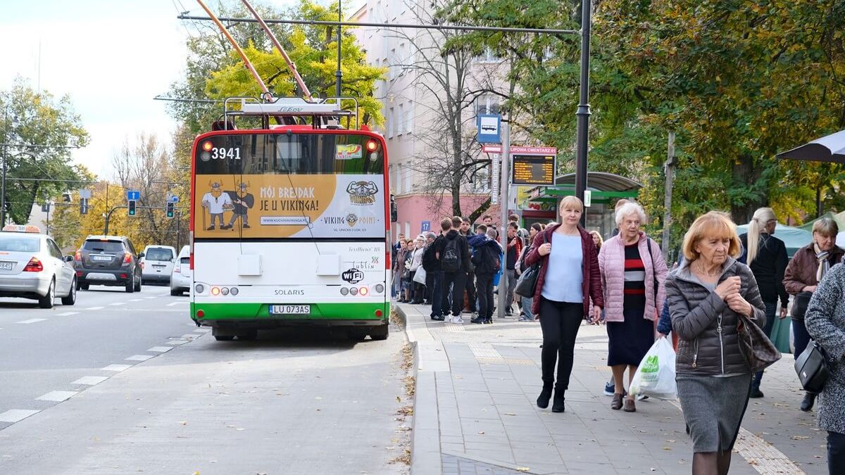 Pasażerowie oczekujący na przystanku, trolejbus na zatoce przystankowej przy ul. Lipowej