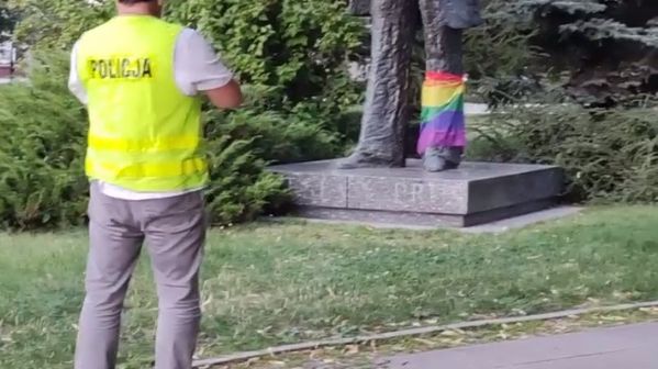 Policjant robiący zdjęcie pomnikowi