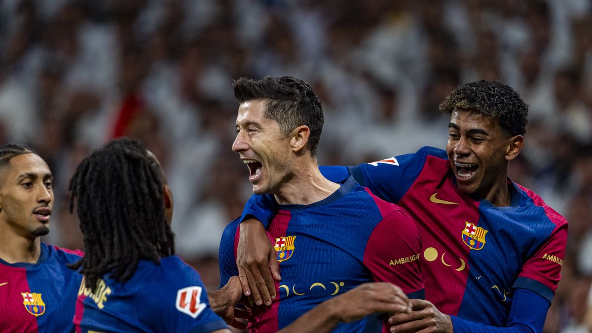 Robert Lewandowski of FC Barcelona (C) celebrates his goal with Lamine Yamal of FC Barcelona (R) and Jules Kounde (L) during the La Liga EA Sports 2024/25 football match between Real Madrid CF and FC Barcelona at Estadio Santiago Bernabeu in Madrid, Spain, on October 26, 2024. (Photo by Alberto Gardin/NurPhoto via Getty Images)