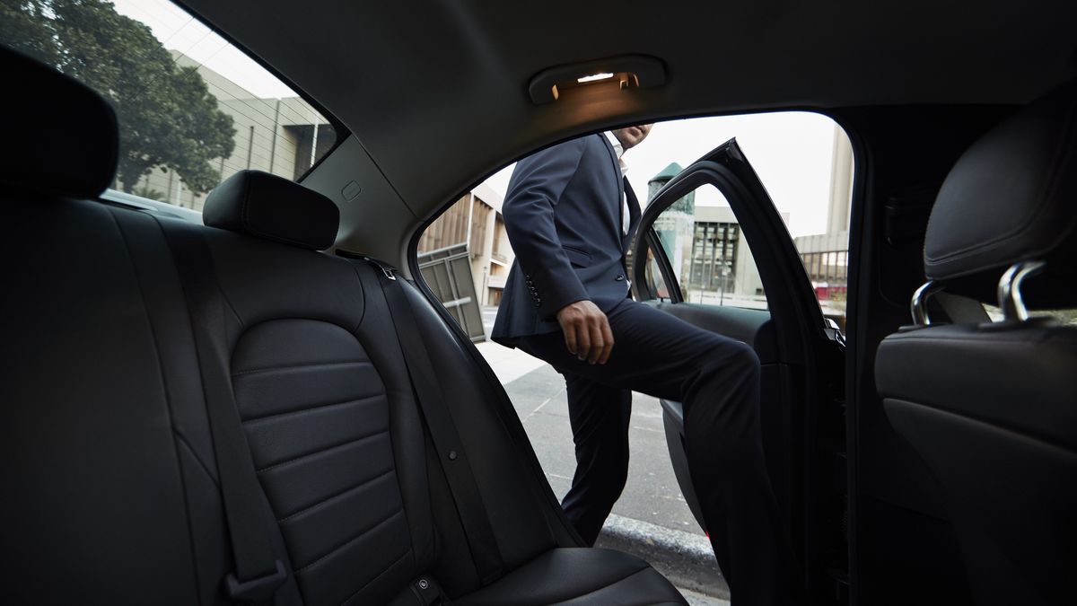 Mężczyzna w garniturze wsiadający na tylne siedzenia samochodu