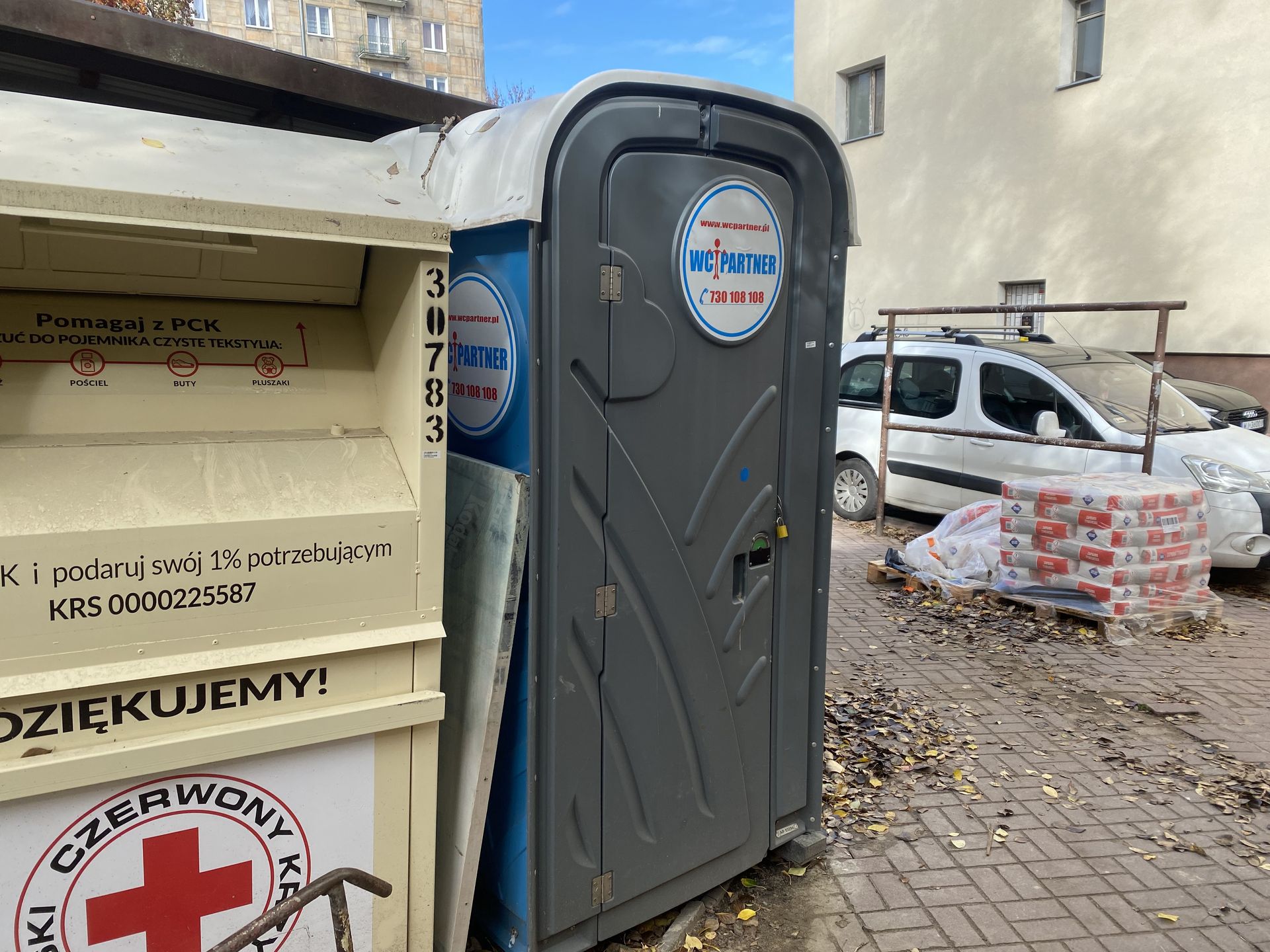 Przenośna toaleta, która znajduje się pomiędzy kamienicami 