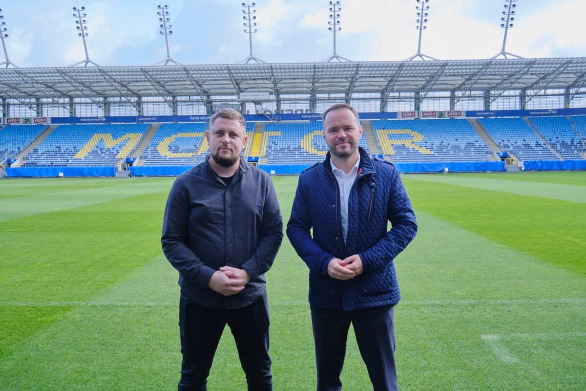 Rzecznik Motoru Lublin Bartłomiej Adamiak i wiceprezes MOSiRu Krzysztof Komorski na tle napisu MOTOR na Arenie Lublin