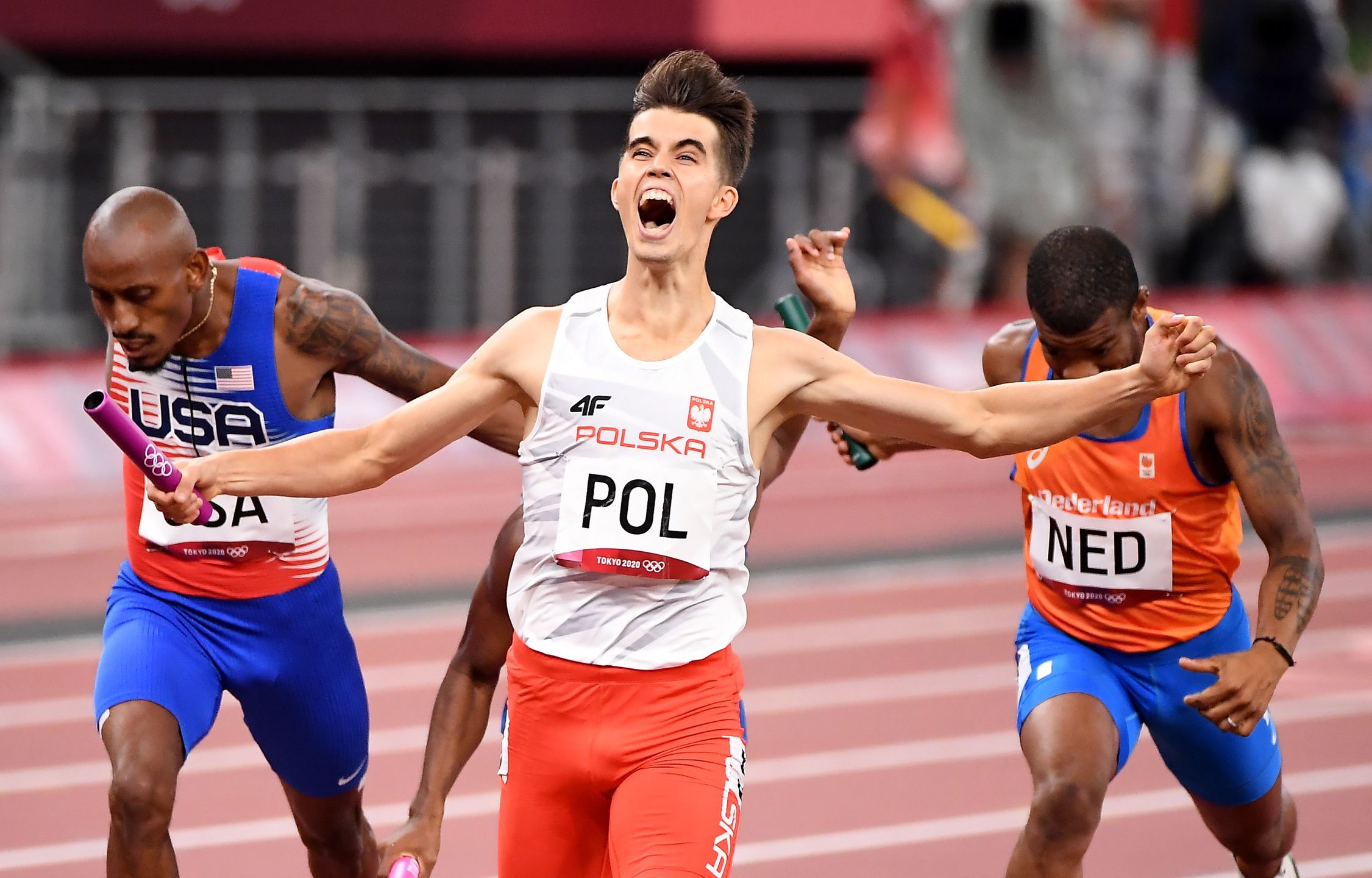 -TOKYO,JAPAN July 31, 2021: Kajetan Duszynski crosses the finish line first for team Poland and capture the 4X400 relay mixed race at the 2020 Tokyo Olympics.  (Wally Skalij /Los Angeles Times via Getty Images)