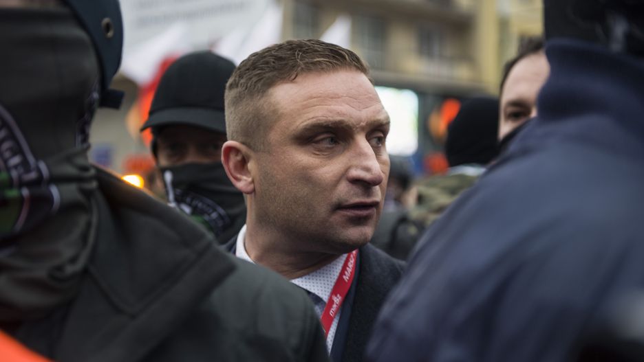 WARSAW, POLAND - 2020/11/11: Robert Bakiewicz, president of the Independence March Association looking on with his bodyguards during Independence Day.
Thousands took part in an annual far-right march in Warsaw to mark Polands Independence Day, defying coronavirus restrictions. An apartment next to the Poniatowski Bridge was set on fire allegedly for being decorated with rainbow flags and Womens Strike banners. This year's Independence Day March was planned in a motorised formula. (Photo by Attila Husejnow/SOPA Images/LightRocket via Getty Images)