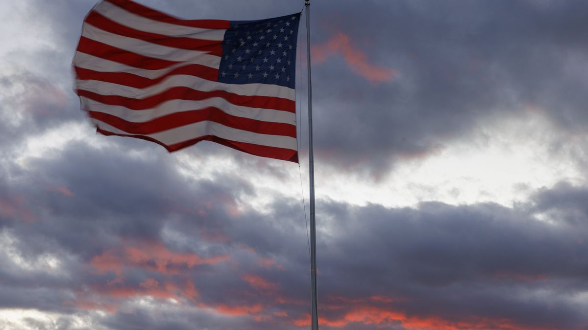 BLOOMINGTON, INDIANA - NOVEMBER 26: As the American flag waves in a cold wind sunset bathes the skies in crimson on Nov. 26, 2025, in Bloomington, Indiana. (Jeremy Hogan/Getty Images)