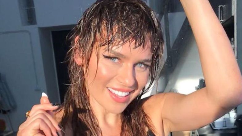 Natasza Urbańska pozuje w otoczeniu przyrody i zielonkawej wody