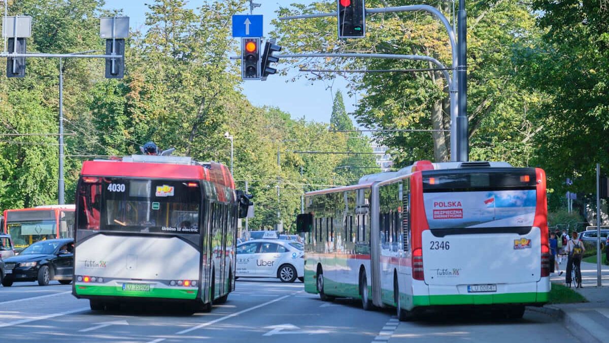 autobus elektryczny i autobus przegubowy przed skrzyżowaniem