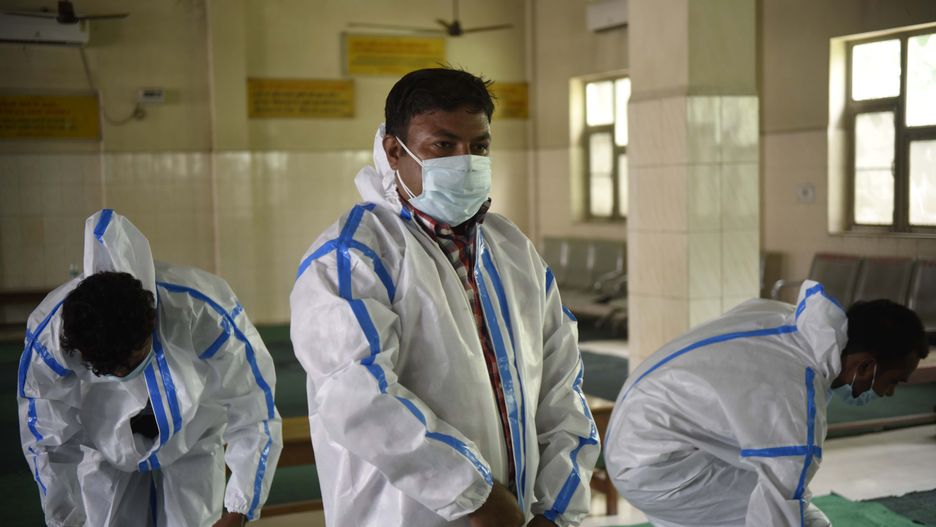 GURUGRAM, INDIA - JUNE 19:  MCG health workers put on personal protective equipment (PPE) before the cremation of a COVID-19 victim, at Madan Puri Cremation Ground on June 19, 2020 in Gurugram, India.  (Photo by Parveen Kumar/Hindustan Times via Getty Images)