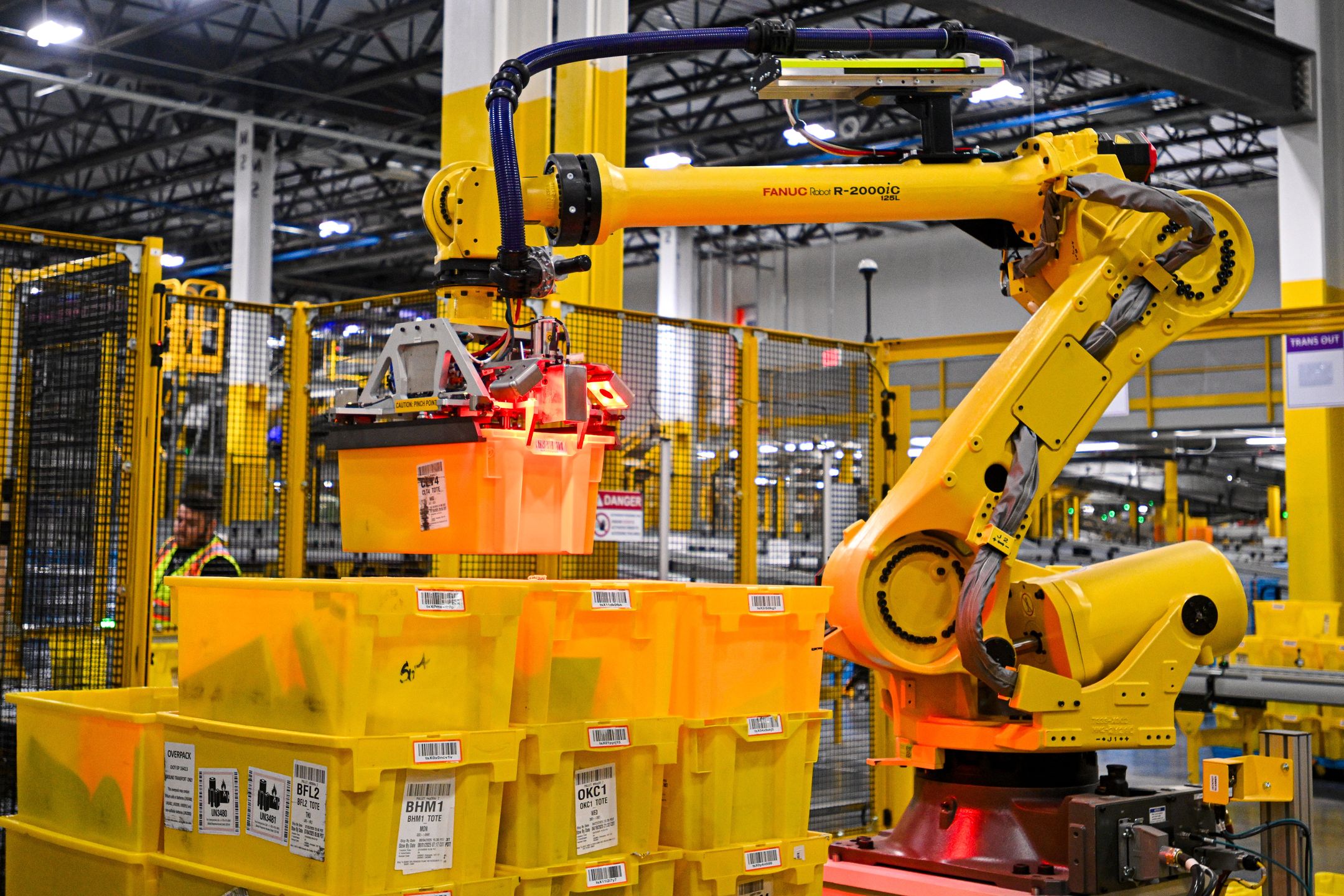 A Fanuc robotic arm moves bins of products during a media tour of the Amazon.com Inc. DAB2 fulfillment center in Daytona Beach, Florida, US, on Tuesday, Sept. 23, 2025. The DAB2 fulfillment center is Amazon's seventh robotics fulfillment center in Florida. Photographer: Miguel J. Rodriguez Carrillo/Bloomberg via Getty Images