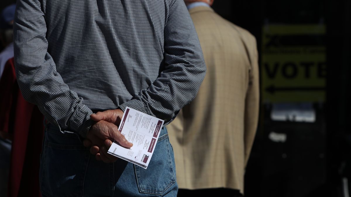 A voter holds his Elections Canada information card while standing in line at a polling station during a federal election in Montreal, Quebec, Canada, on Monday, Sept. 20, 2021. Canadian Prime Minister Trudeau appears set to retain power in a close election Monday, but may fall short of regaining the parliamentary majority he's been coveting. Photographer: David Kawai/Bloomberg via Getty Images