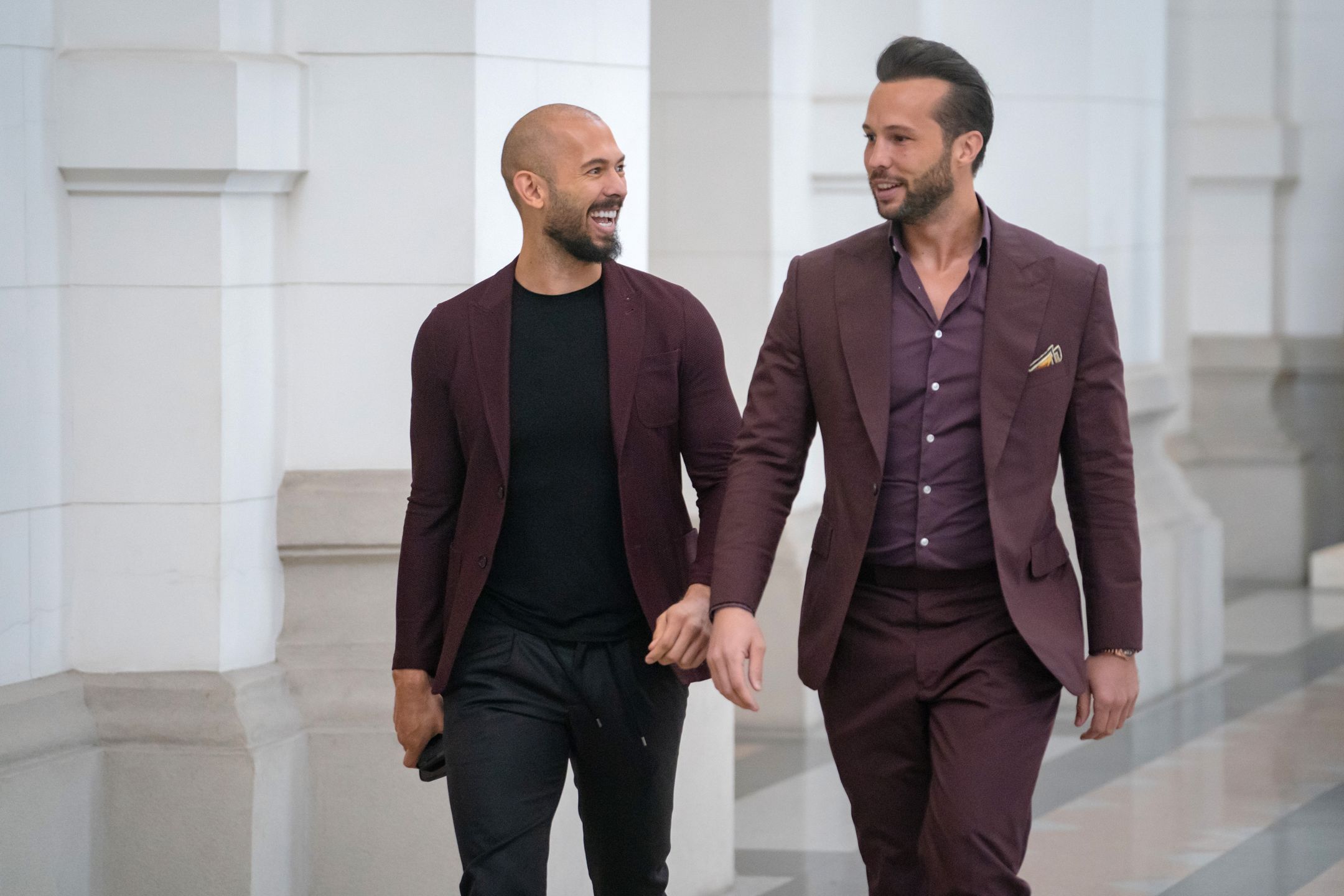 BUCHAREST, ROMANIA - OCTOBER 15: Andrew Tate (left) and his brother Tristan Tate walk inside the Court of Appeal on October 15, 2024 in Bucharest, Romania. Social Media Influencer Andrew Tate and his brother Tristan are appearing in court to appeal a decision to proceed with their trial on charges of rape, human trafficking and forming a criminal gang to exploit women. The Tate brothers were arrested on December 29, 2022, alongside Georgiana Naghel and Luana Radu as part of an investigation into human trafficking and rape. (Photo by Andrei Pungovschi/Getty Images)