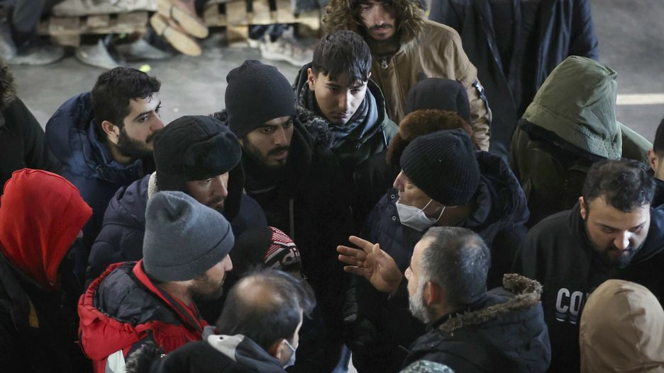 TemporaryMigrants talk in the logistics center of the checkpoint "Bruzgi" at the Belarus-Poland border near Grodno, Belarus, Wednesday, Dec. 1, 2021. The West has accused Belarusian President Alexander Lukashenko of luring thousands of migrants to Belarus with the promise of help to get to Western Europe to use them as pawns to destabilize the 27-nation European Union in retaliation for its sanctions on his authoritarian government. Belarus denies engineering the crisis. (Oksana Manchuk/BelTA via AP)BelTA