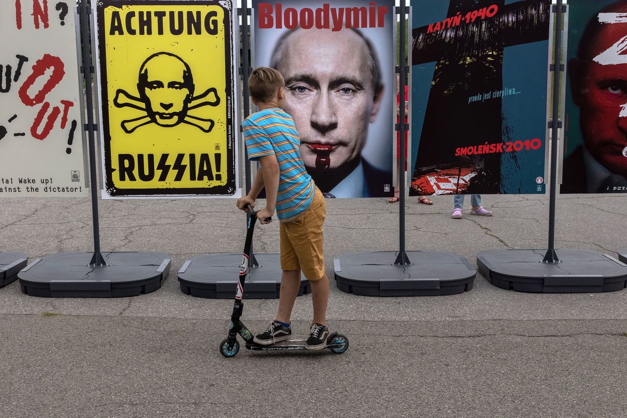 Chłopiec przygląda się wystawie antyputinowskich plakatów przed ukraińskim Narodowym Muzeum Historycznym