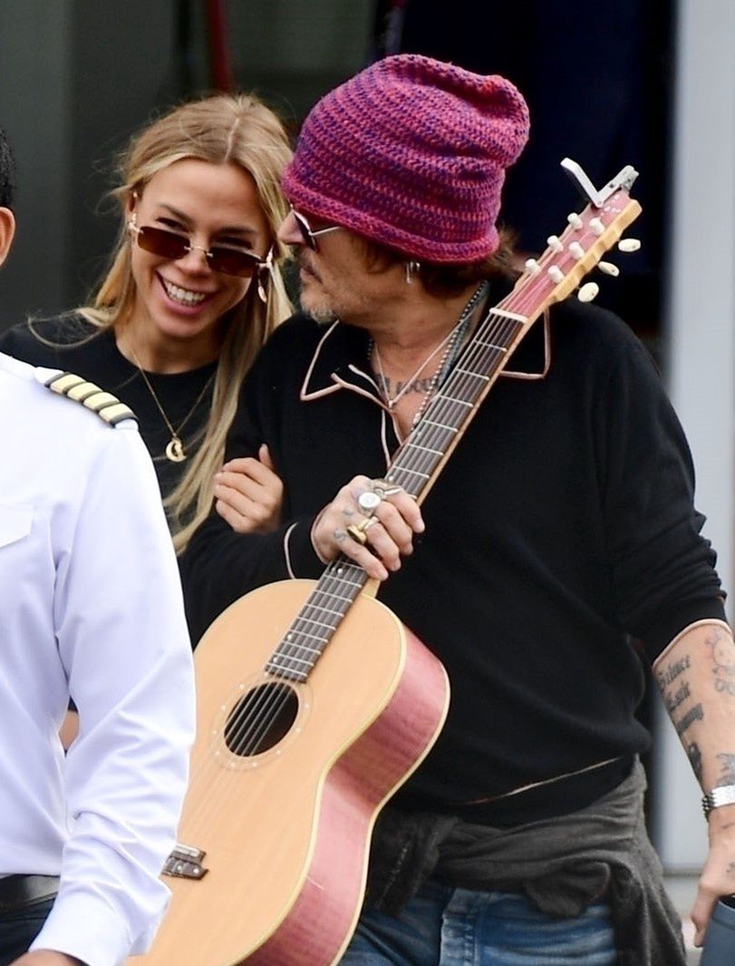 Johnny Depp rushes through the airport alongside a mysterious blonde.