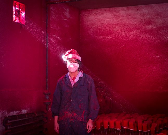 Drugie miejsce w kategorii - współczesne zagadnienia (contemporary issues) zostało przyznane za zdjęcie 19 letniego, chińskiego robotnika, który ma na sobie maskę i kapelusz Świętego Mikołaja. Znajduje się w fabryce, wytwarzającej ozdoby świąteczne. Światło wpadające przez okno podświetla czerwony proszek, który służy do barwienia ozdób. Robotnik nosi 6 masek dzienni, a kapelusz chroni jego włosy przed kolorowym pyłem.