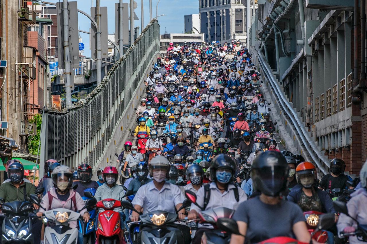 19.07.2021 r., Tajpej, Tajwan. Ulica zapchana przez ludzi przemieszczających się na skuterach. Wszyscy mają maseczki. Podczas wzmożonego rozprzestrzeniania się wariantu Alfa, na Tajwanie były bardzo silne obostrzenia oraz kontrola. Współczynnik wszystkich zakażeń był aż 190 razy mniejszy niż w USA w tym samym czasie.