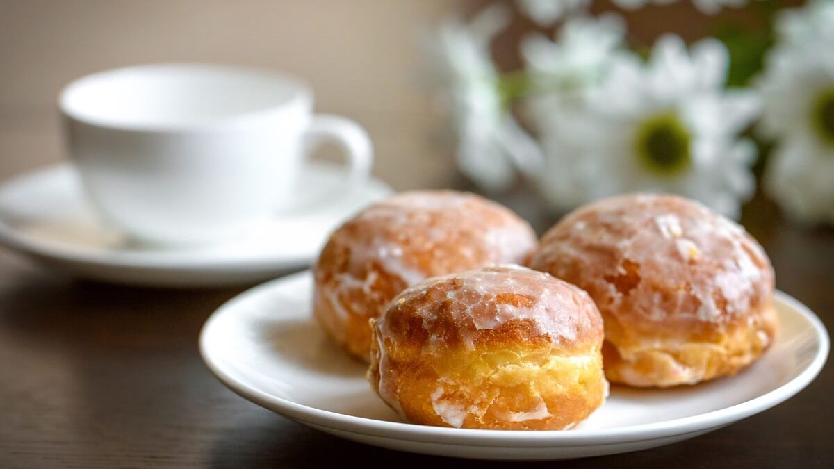 pączki na talerzyku podane z filiżanką kawy