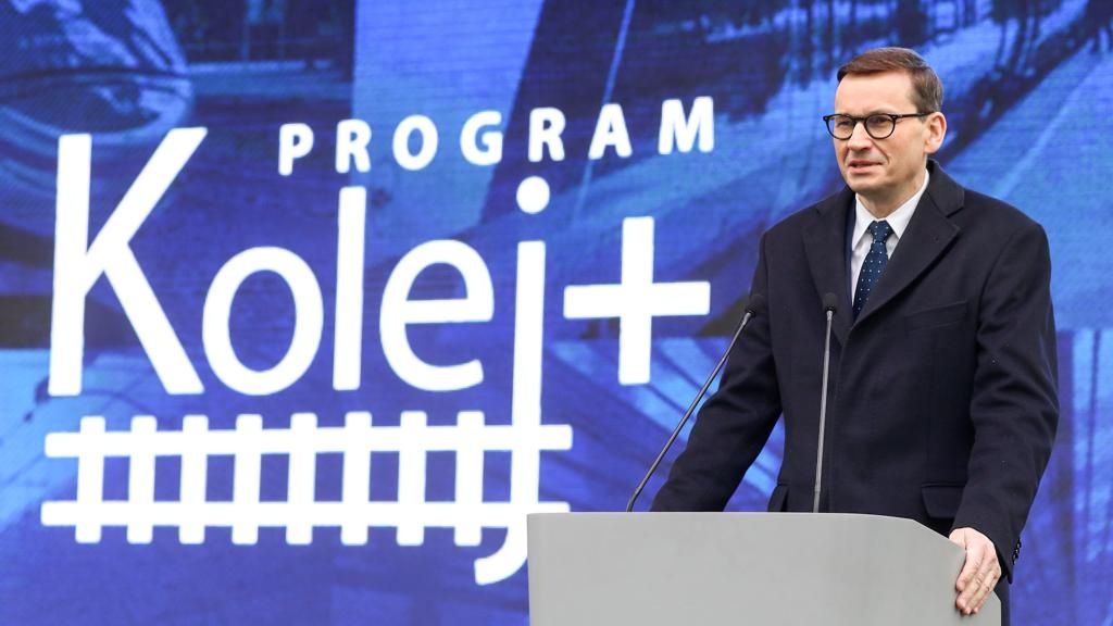 Na zdjęciu premier Mateusz Morawiecki po prawej stronie kadru. Po lewej logo programu Kolej Plus