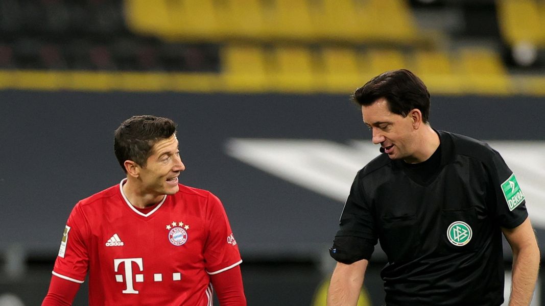 Robert Lewandowski (z lewej) rozmawia z sędzią