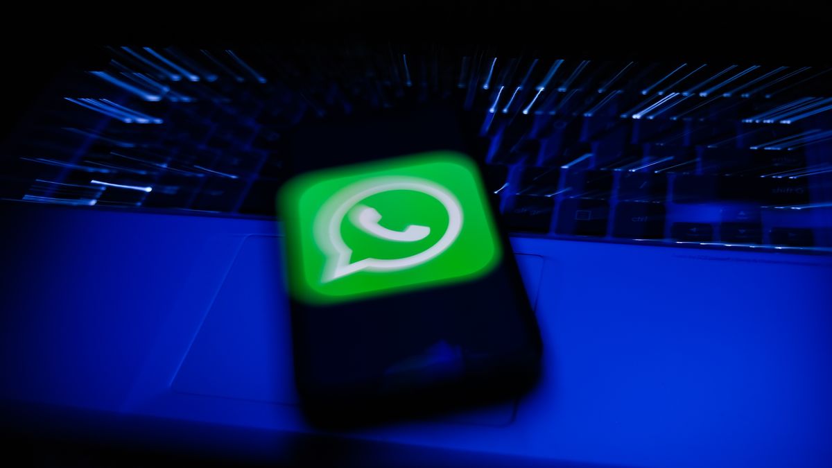 WhatsApp logo displayed on a phone screen and a laptop keyboard are seen in this long exposure illustration photo taken in Krakow, Poland on February 6, 2022. (Photo illustration by Jakub Porzycki/NurPhoto via Getty Images)