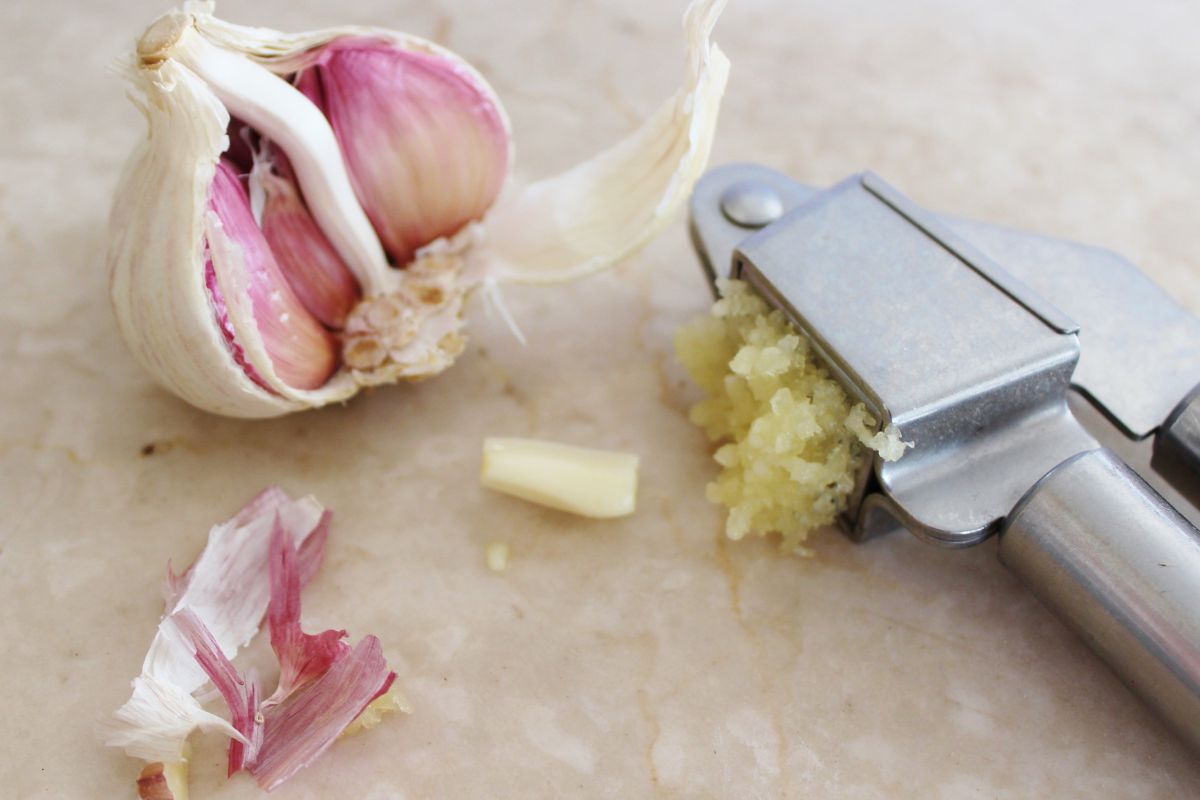 The garlic press will retain the peel, and the cloves of the herb will be crushed.