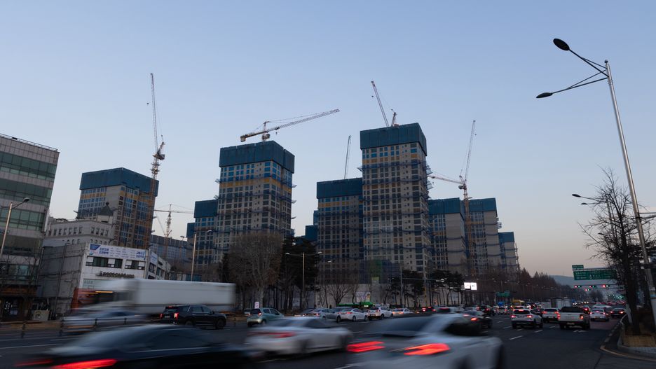 Vehicles drive past Olympic Park Foreon residential apartment buildings under construction in Seoul, South Korea, on Tuesday, Jan. 10, 2022. The vast Dunchon project in Seoul is designed to accommodate more than 10,000 households and has been one of the most anticipated developments in a country that heavily favors apartments. But it has run up against a looming glut of new homes and a string of interest-rate hikes by the Bank of Korea that has pushed up borrowing costs and turned buyers wary. Photographer: SeongJoon Cho/Bloomberg via Getty Images