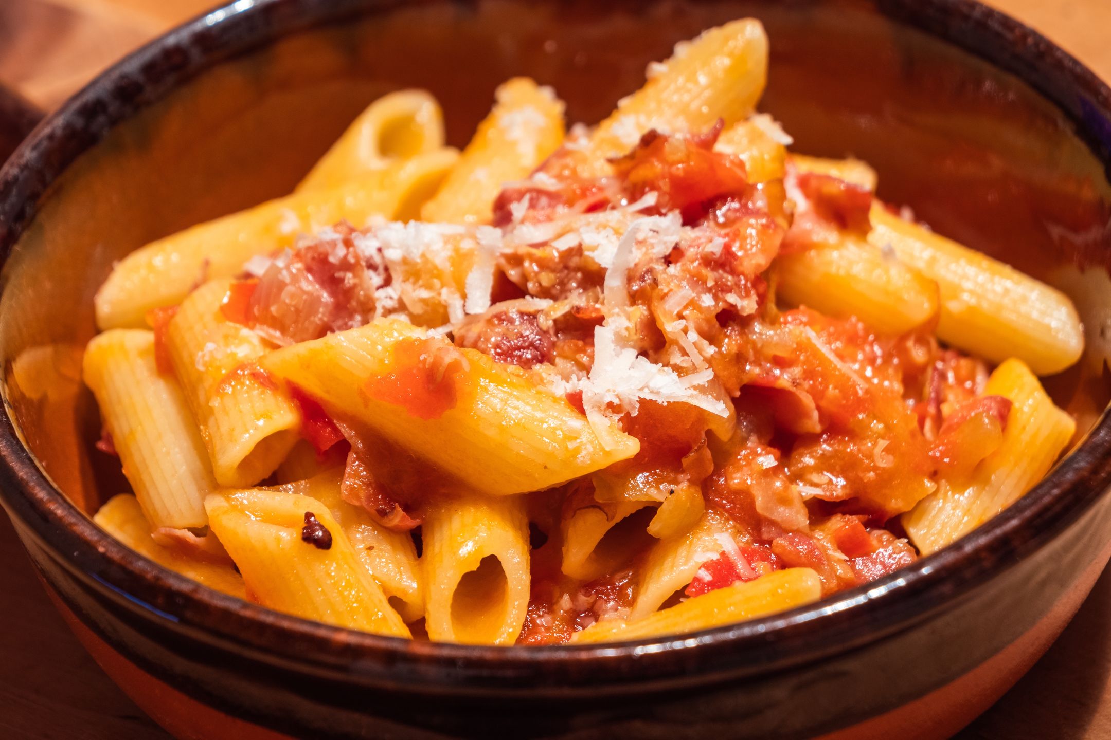 Penne all Arrabiata Pasta or Noodle Dish with Parmesan Cheese on a Rustic Tableall, all'arrabbiata, allarrabbiata, arabiata, arabiatta, arrabbiata, arrabbiata sauce, arrabiata, arrabiatta, bacon, bowl, cheese, chili, chilli, cuisine, delicious, dinner, dish, food, fork, fresh, homemade, hot, italian, italy, knife, lazio, lunch, meal, noodle, parmesan, pasta, penne, pepper, plate, red, rigate, roman, rustic, sauce, serving, spicy, sugo, sugo all'arrabbiata, table, tasty, tomato, traditional, wood