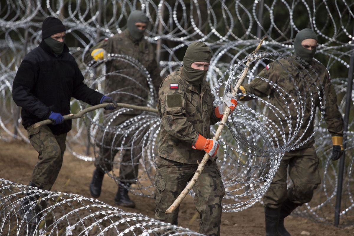 Żołnierze na granicy polsko-białoruskiej rozstawiający drut kolczasty