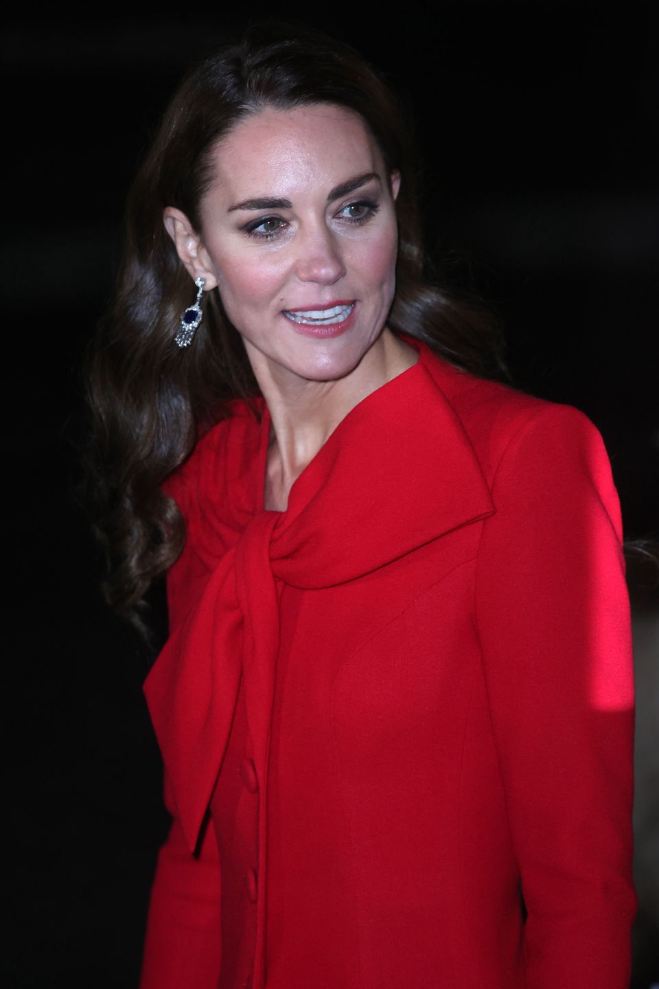 Kate Middleton w czerwonej sukience-płaszczu kolęduje z księciem Williamem