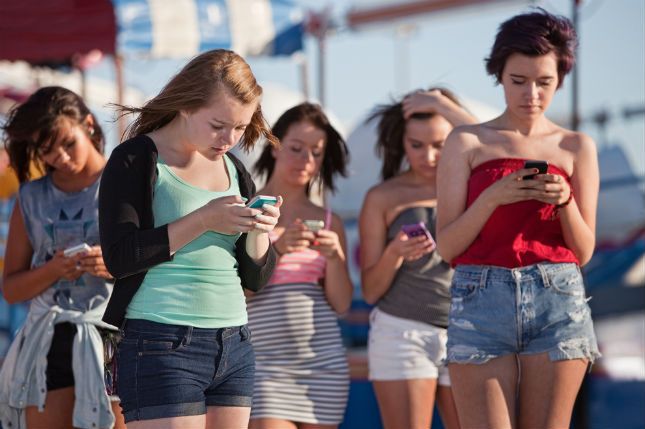 Zdjęcie nastolatek ze smartfonami pochodzi z serwisu Shutterstock