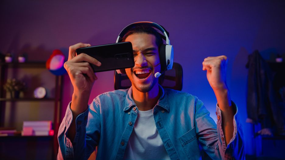 Happy asia man gamer wear headphone competition play video game online with smartphone colorful neon light in living room at night modern house. Esport streaming game online, Home quarantine activity.
game, play, phone, asian, gamer, stream, esport, online, livestream, smartphone, teenager, entertainment, headphones, man, technology, internet, broadcast, chat, male, player, vlogger, young, guy, happy, neon, victory, cybersport, win, excited, microphone, live, home, headset, mobile, cyber, action, person, adult, fun, competition, digital, hobby, room, talk, joy, smile, night, latin, indian, millennial