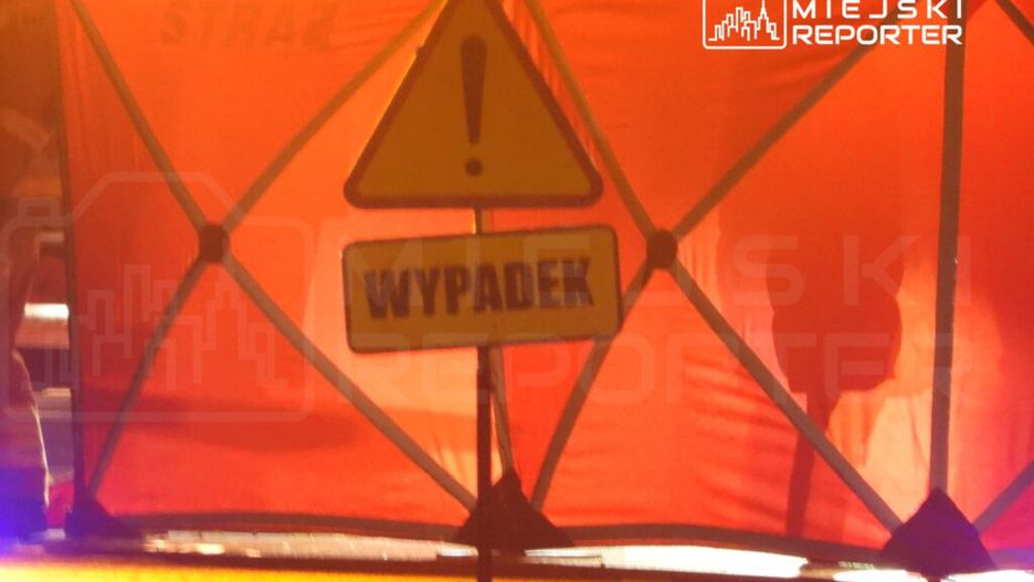 Czerwony namiot policyjny z napisem "WYPADA" ustawiony na drodze, sygnalizujący miejsce wypadku.