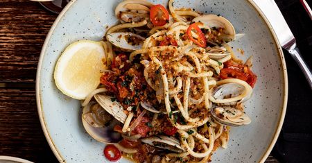 Spaghetti z małżami Wenus, pomidorkami koktajlowymi i chrupiącą posypką