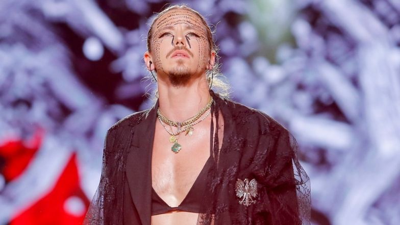 Michał Szpak pozuje wyleguje się w pościeli w staniku