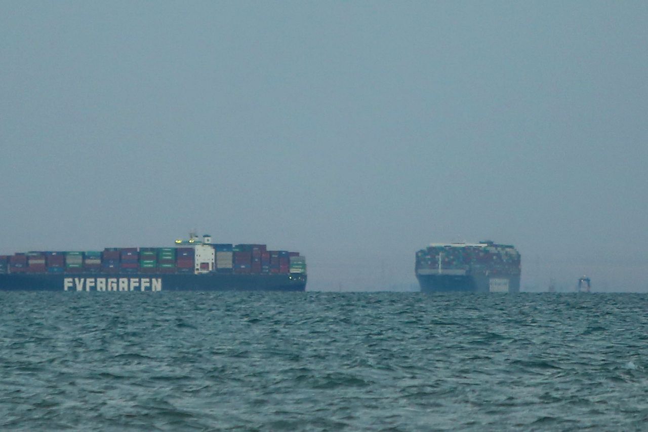 The Ever Given container ship, right, enters the Great Bitter Lake after being freed from the Suez Canal in Suez, Egypt, on Monday, March 29, 2021. The giant Ever Given container ship was finally pulled free from the bank of the Suez Canal, allowing for a massive tail back of ships to start navigating once again through one of the worlds most important trade routes. Photographer: Islam Safwat/Bloomberg via Getty Images