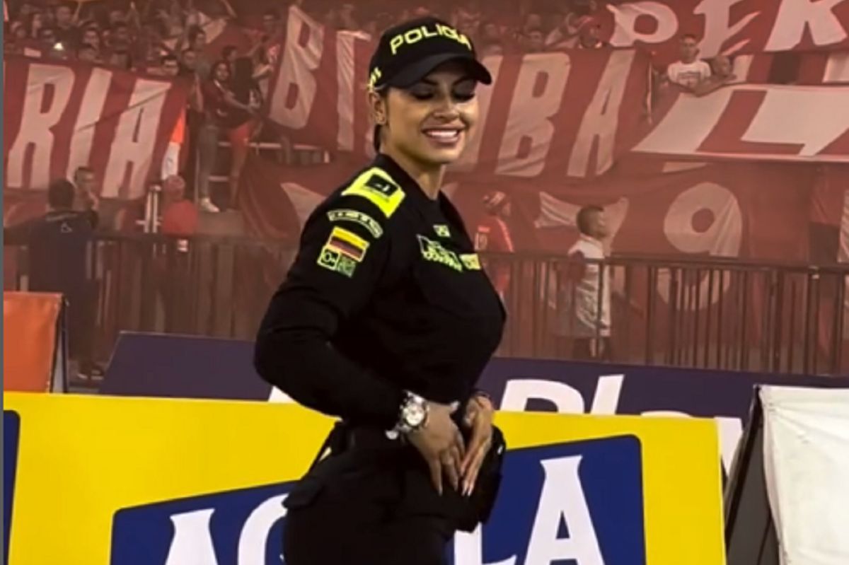 A beautiful policewoman keeps order at the stadium. She wins the hearts of fans.