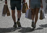 A couple of visitors seen with shopping bags in Florianska Street, in Krakow's Old Town.
On Tuesday, July 12, 2022, in Krakow, Poland. (Photo by Artur Widak/NurPhoto via Getty Images)