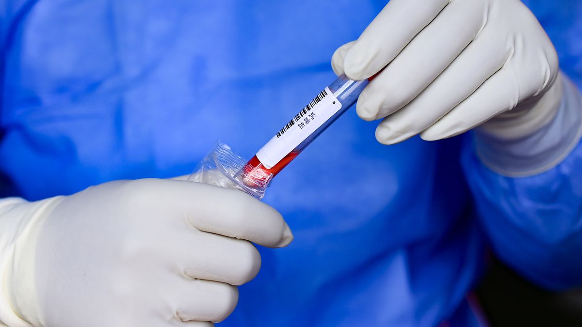 HOHHOT, CHINA - NOVEMBER 30, 2022 - A medical worker wraps nucleic acid sampling tubes at a residential complex in Hohhot, Inner Mongolia, China, November 30, 2022. (Photo credit should read CFOTO/Future Publishing via Getty Images)